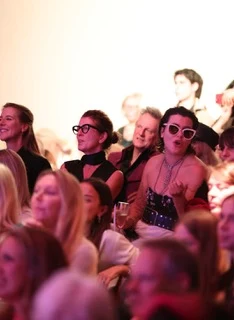 Members of the audience seated in the church watching the show