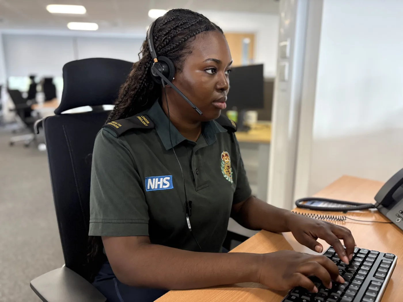 111 health adviser Abigail Oluwasanya at her desk in a London Ambulance Service control room
