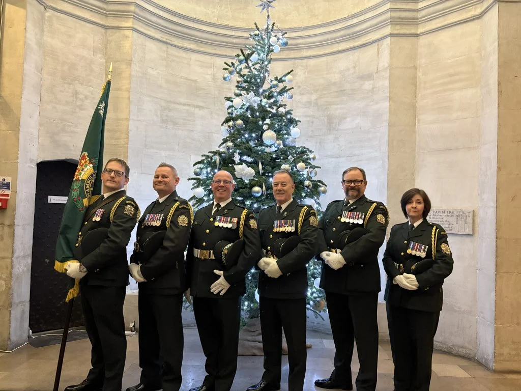 The London Ambulance Service Ceremonial Unit beside a Christmas tree at the 2025 carol concert