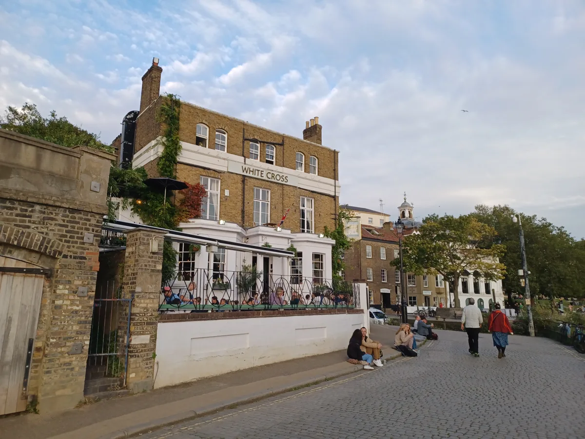 The White Cross on the riverside at Richmond, with drinkers on the terrace and the towpath in front